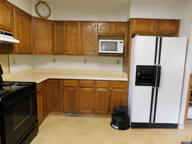 295 N 1st Street E, St, Green River, WY 82935 - kitchen with white appliances, under cabinet range hood, brown cabinetry, and light countertops