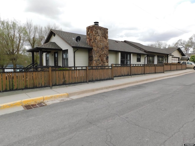 295 N 1st Street E, St, Green River, WY 82935 - view of front of house with a fenced front yard, a shingled roof, and a chimney