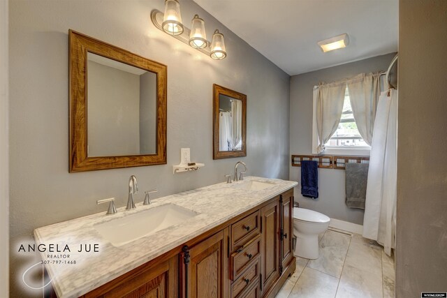 bathroom with toilet and double vanity