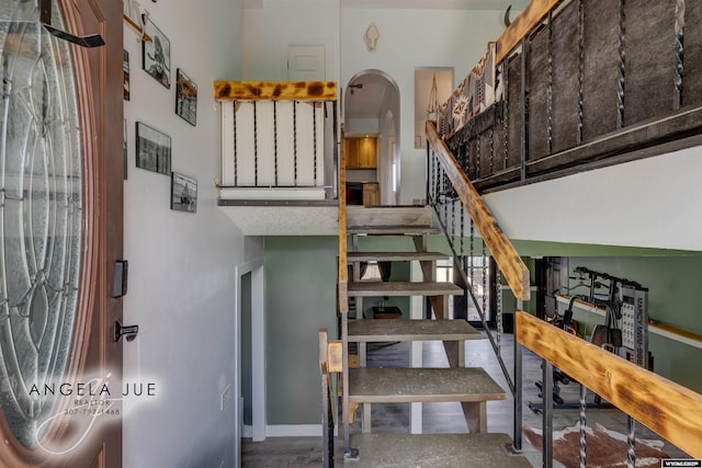 staircase featuring arched walkways