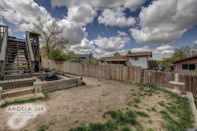 view of yard with stairs and fence