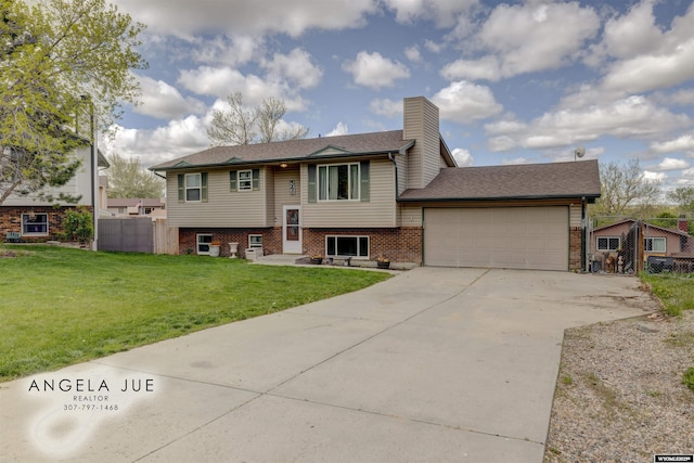 split foyer home featuring a garage, driveway, a chimney, and brick siding