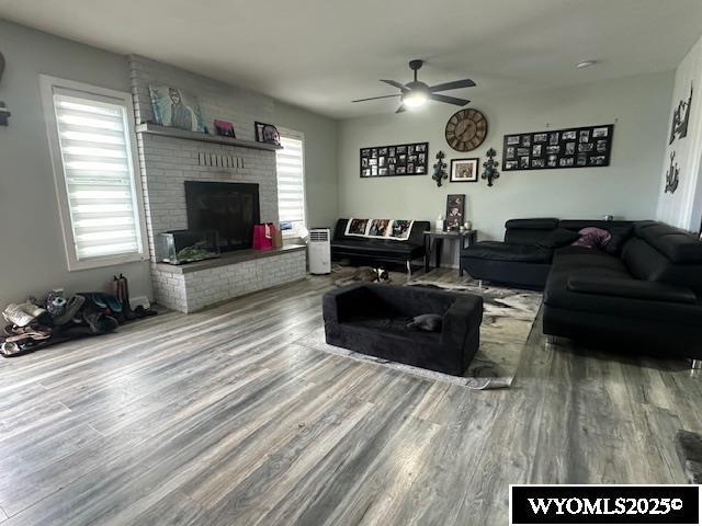 408 S 18th, Worland, WY 82401 - living room with wood finished floors, ceiling fan, a fireplace, and healthy amount of natural light