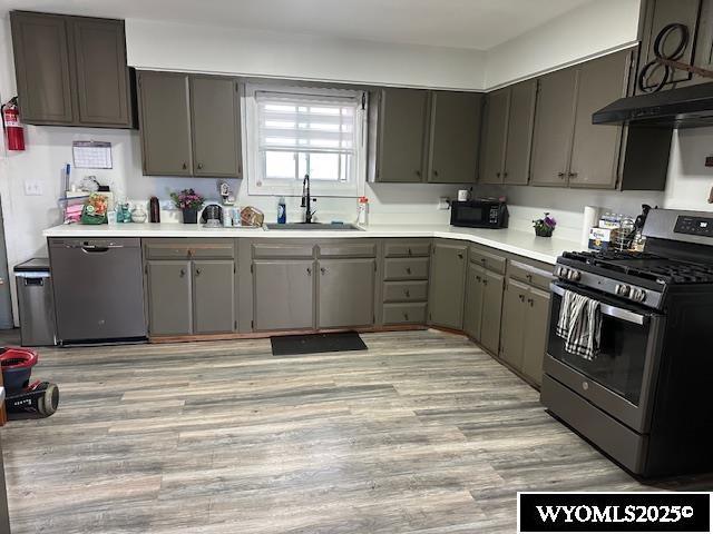 408 S 18th, Worland, WY 82401 - kitchen featuring stainless steel range with gas stovetop, a sink, dishwasher, under cabinet range hood, and light countertops