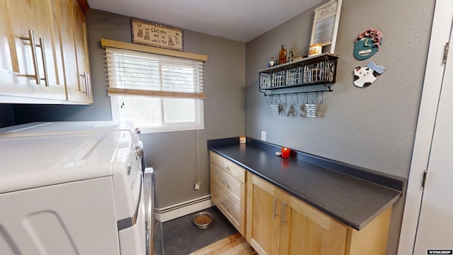 laundry area with cabinet space, baseboard heating, separate washer and dryer, and baseboards