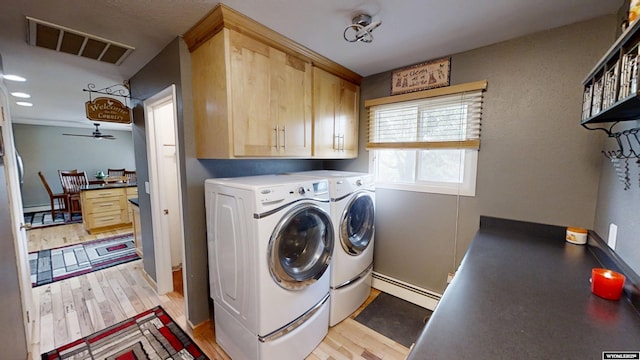 clothes washing area featuring a baseboard heating unit, cabinet space, independent washer and dryer, light wood-type flooring, and a ceiling fan