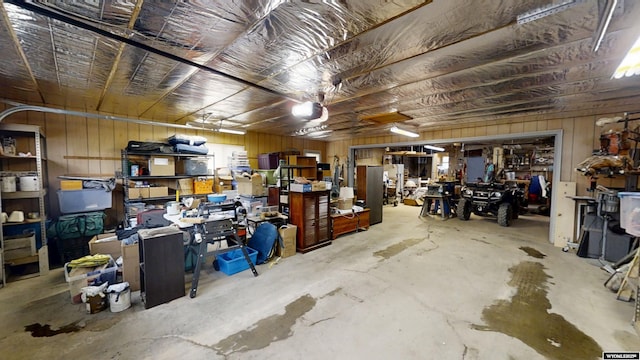 garage featuring a garage door opener, wood walls, and refrigerator