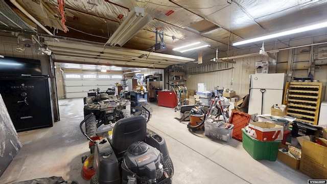 garage with a garage door opener and freestanding refrigerator