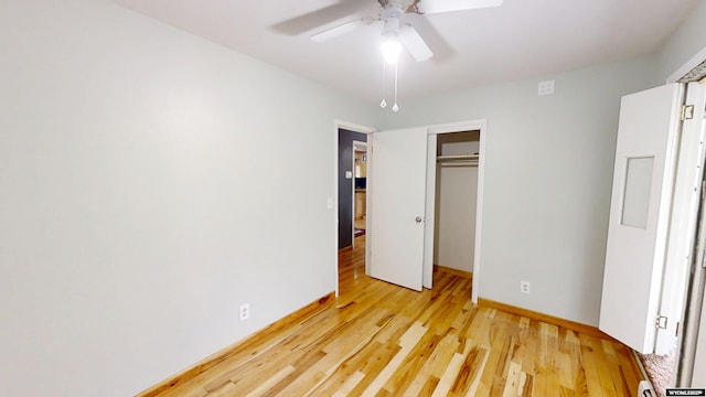 unfurnished bedroom featuring light wood-style flooring, a closet, baseboards, and ceiling fan