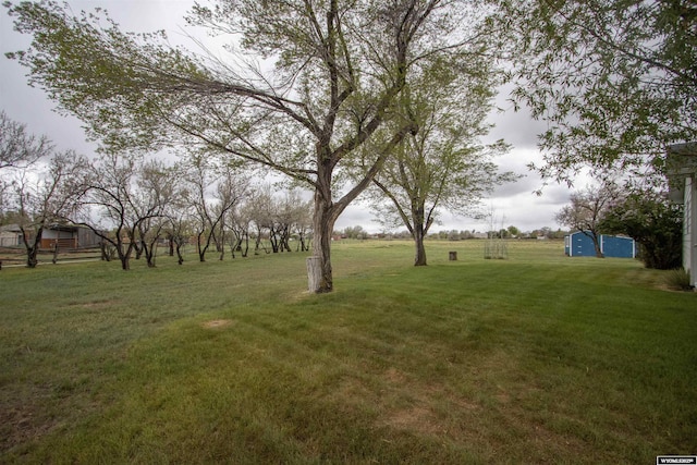 view of grassy yard with an outdoor structure