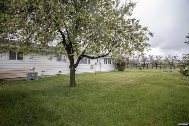 view of grassy yard with central AC unit