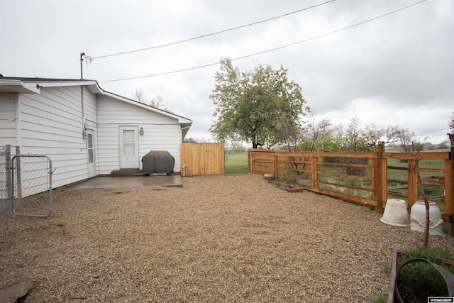 fenced backyard with a patio and a gate