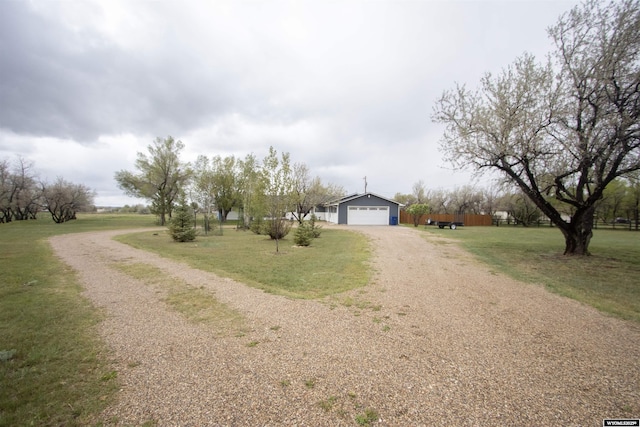 view of front facade featuring dirt driveway, a front lawn, and a garage