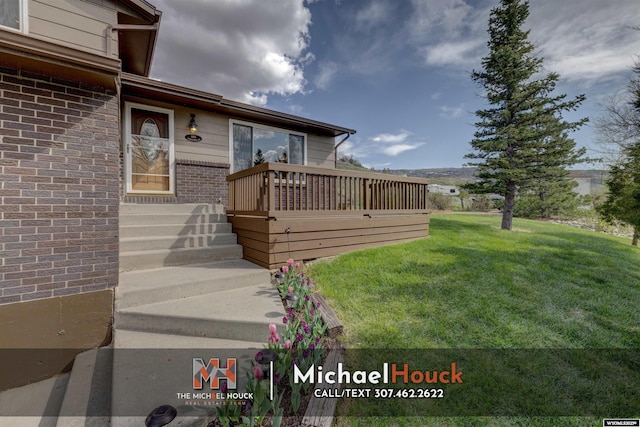 view of green lawn featuring a wooden deck