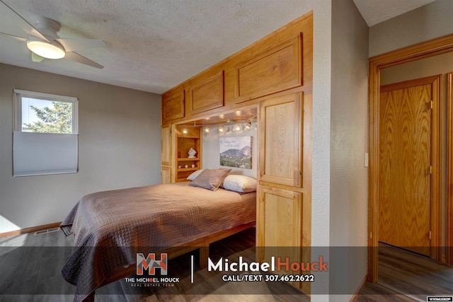 bedroom featuring a textured ceiling, wood finished floors, and baseboards