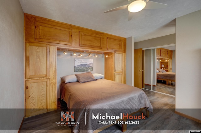 bedroom with dark wood-type flooring, a ceiling fan, baseboards, and a closet