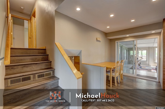 staircase featuring wood finished floors and recessed lighting