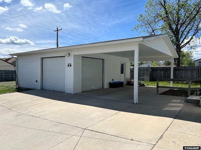 1208 10th St, Wheatland, WY 82201 - garage featuring fence, a garage, and driveway