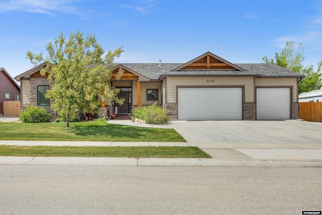 view of front of property featuring an attached garage, stone siding, driveway, and roof with shingles