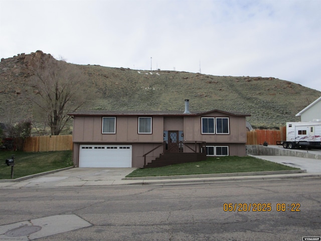 670 Easy St, Green River, WY 82935 - raised ranch with concrete driveway, a mountain view, and a garage