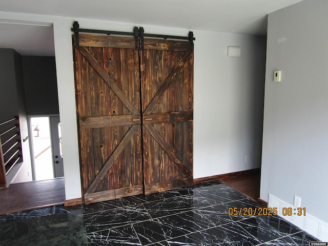 670 Easy St, Green River, WY 82935 - bedroom featuring marble finish flooring, a barn door, and baseboards