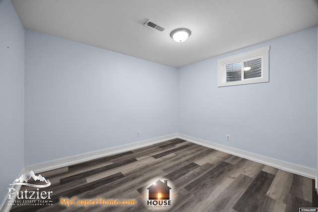empty room featuring dark wood-type flooring and baseboards