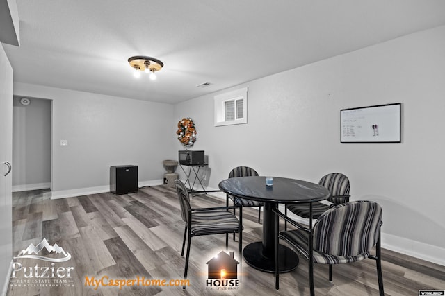 dining space with wood finished floors and baseboards