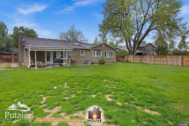 rear view of house with a chimney, a patio area, and a shingled roof
