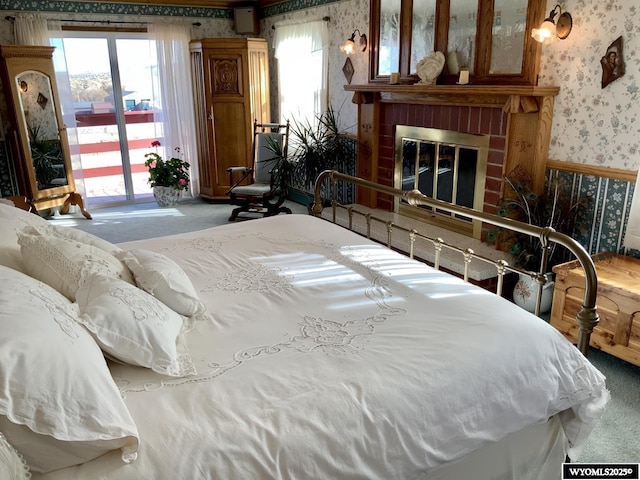 19A Kolman Ranch Rd, Rock Springs, WY 82901 - bedroom with wallpapered walls, carpet, access to exterior, a fireplace, and multiple windows