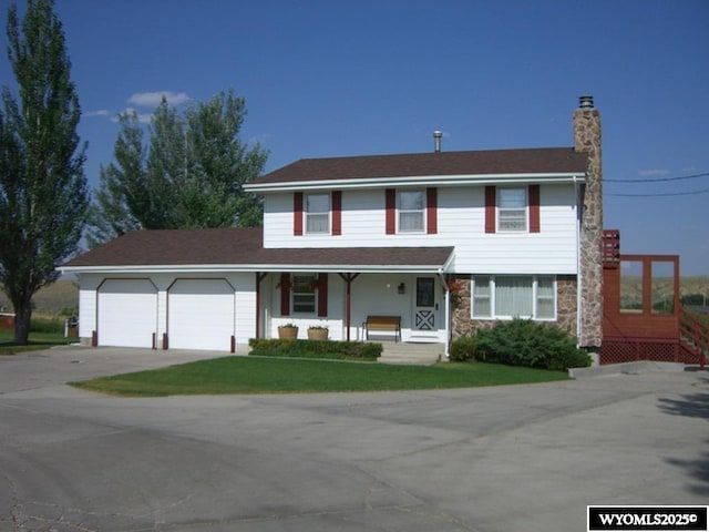 19A Kolman Ranch Rd, Rock Springs, WY 82901 - traditional-style home featuring covered porch, driveway, a chimney, an attached garage, and a front yard