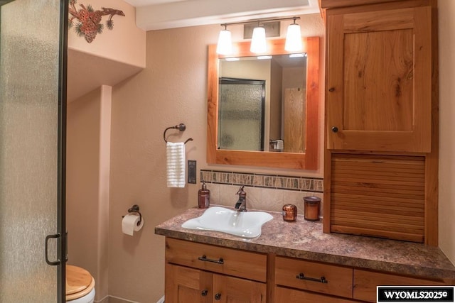 19A Kolman Ranch Rd, Rock Springs, WY 82901 - bathroom with vanity, toilet, tasteful backsplash, an enclosed shower, and baseboards
