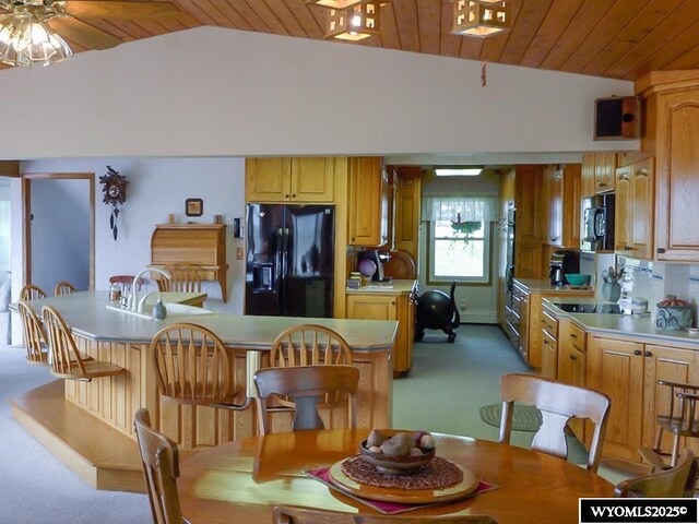 19A Kolman Ranch Rd, Rock Springs, WY 82901 - dining space featuring vaulted ceiling, light colored carpet, wood ceiling, and a ceiling fan