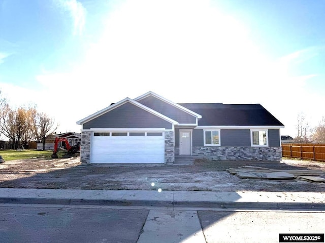 303 E Village Dr, Lyman, WY 82937 - view of front of property featuring stone siding, dirt driveway, and a garage