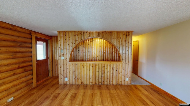 7 Raschell Ct, Lander, WY 82520 - empty room with wood finished floors, log walls, and a textured ceiling