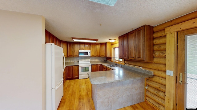 7 Raschell Ct, Lander, WY 82520 - kitchen with white appliances, a peninsula, rustic walls, light wood-type flooring, and a sink