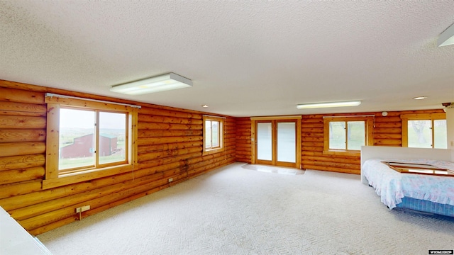 7 Raschell Ct, Lander, WY 82520 - unfurnished bedroom featuring a textured ceiling, rustic walls, and multiple windows