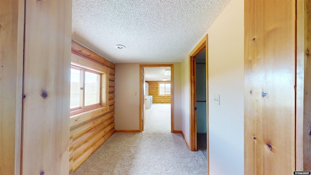 7 Raschell Ct, Lander, WY 82520 - corridor featuring light colored carpet, log walls, a textured ceiling, and baseboards