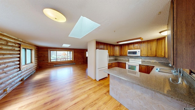 7 Raschell Ct, Lander, WY 82520 - kitchen with white appliances, log walls, a sink, a skylight, and light wood-style flooring