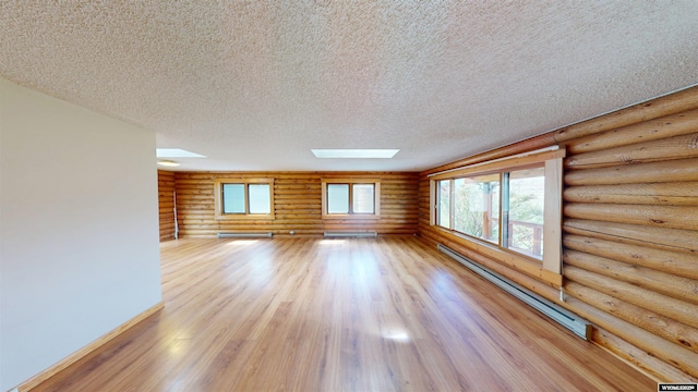 7 Raschell Ct, Lander, WY 82520 - spare room with rustic walls, a skylight, light wood-style flooring, a textured ceiling, and baseboard heating