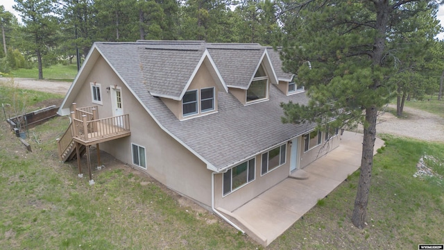 2908 Esterbrook Rd, Esterbrook, WY 82633 - view of side of property featuring stucco siding, roof with shingles, stairs, and view of wooded area