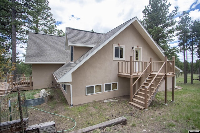 2908 Esterbrook Rd, Esterbrook, WY 82633 - rear view of house featuring stairway, stucco siding, roof with shingles, a deck, and a vegetable garden