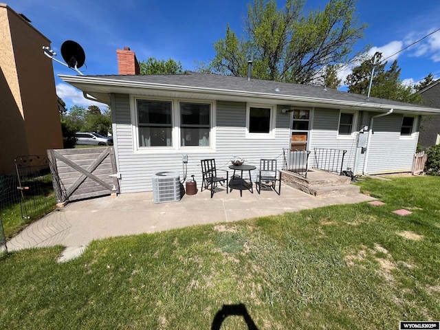rear view of property featuring cooling unit, a patio area, and a chimney
