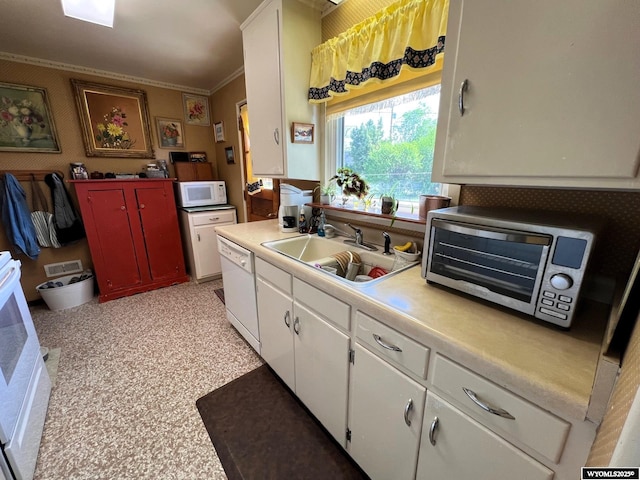 kitchen with white appliances, crown molding, a sink, white cabinetry, and light countertops
