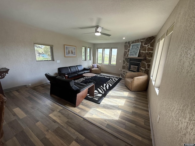41 Ridgewater Ln, Douglas, WY 82633 - living room with a textured wall, wood finished floors, ceiling fan, and a stone fireplace