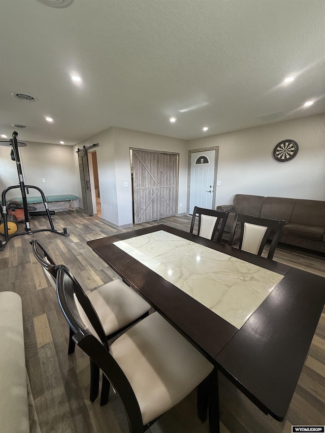 41 Ridgewater Ln, Douglas, WY 82633 - dining room with a barn door, dark wood-style floors, recessed lighting, a textured ceiling, and baseboards