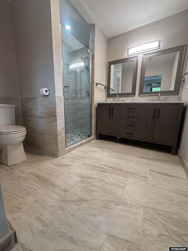 41 Ridgewater Ln, Douglas, WY 82633 - bathroom featuring a stall shower, toilet, double vanity, and tile walls