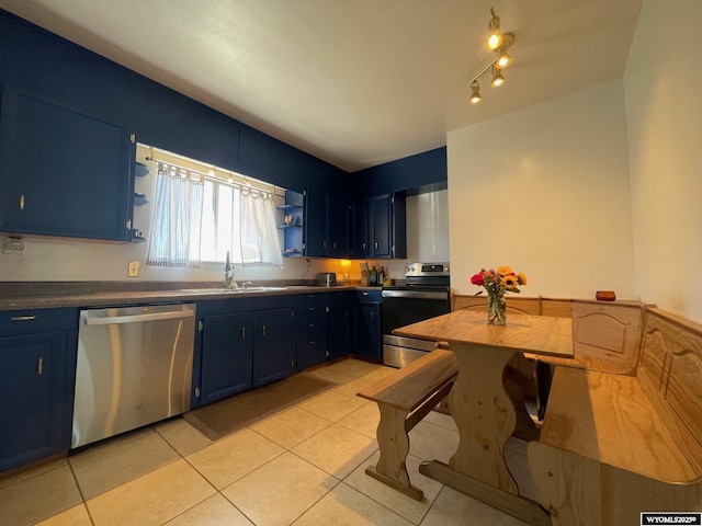 309 Cedar Ave, Kemmerer, WY 83101 - kitchen with stainless steel appliances, blue cabinets, open shelves, a sink, and light tile patterned floors