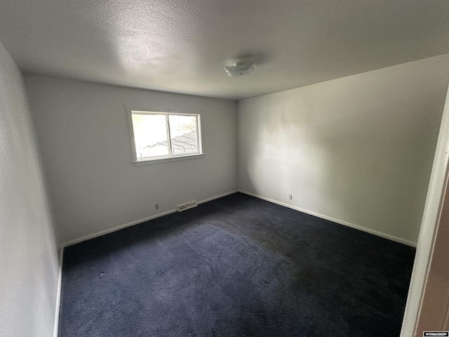 540 Smith, Lander, WY 82520 - empty room with dark colored carpet, baseboards, and a textured ceiling