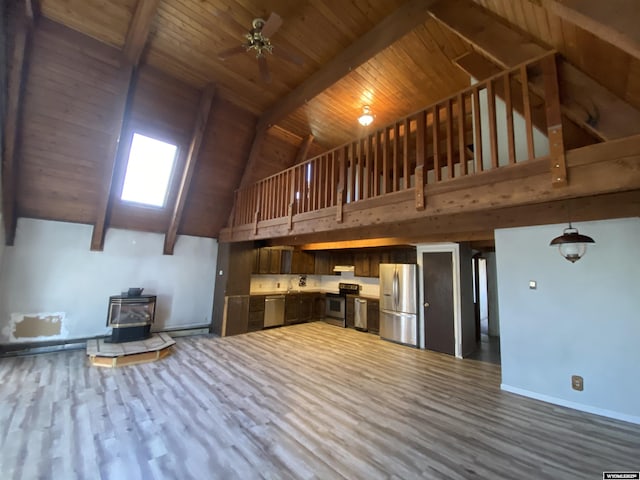 320 Turquoise Dr, Riverton, WY 82501 - unfurnished living room featuring a wood stove, high vaulted ceiling, dark wood-style floors, baseboards, and ceiling fan