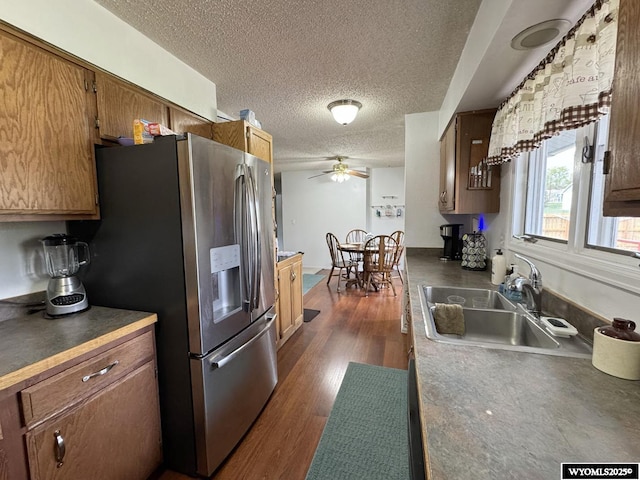 315 Summit Dr, Riverton, WY 82501 - kitchen with a textured ceiling, ceiling fan, stainless steel fridge, a sink, and dark wood finished floors